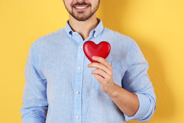 Man holding decorative heart on color background, closeup - Fotoğraf, Görsel