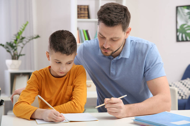 Dad helping his son with homework in room - Zdjęcie, obraz