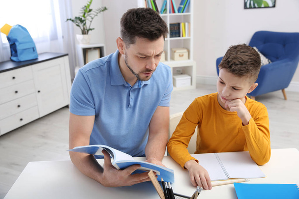 Dad helping his son with homework in room - 写真・画像