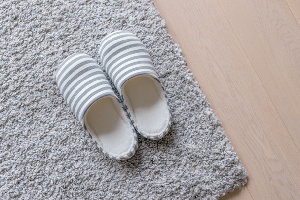 Pantoufles sur tapis sur le sol à la maison
 - Photo, image