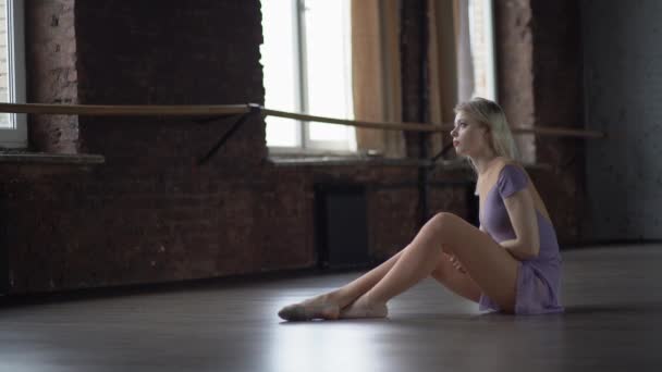 Young blond ballerine upset and sits on the floor. - Footage, Video