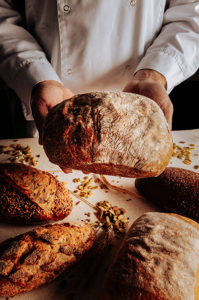 Pane di grano bello nelle mani di un fornaio esperto e professionale
 - Foto, immagini