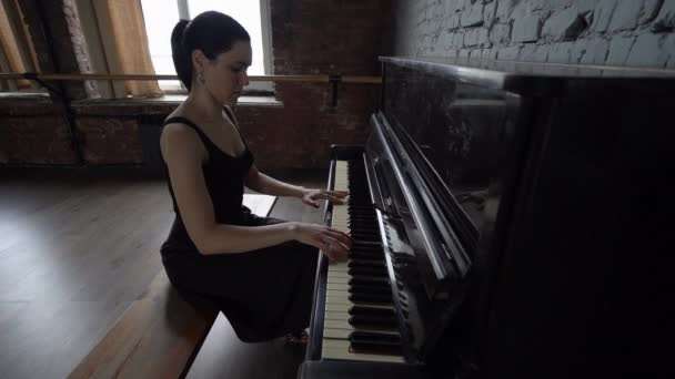 黒いドレスを着た女の子が座って、ピアノ - スローモーション. - 映像、動画