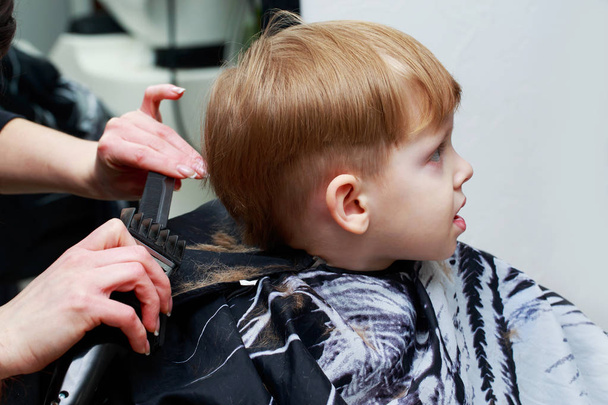 The little boy in the barber shop - Foto, afbeelding