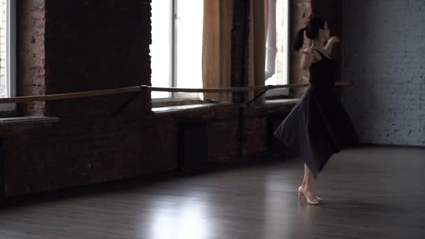 Łaski Pani w czarnej sukni sprawia, że obracając w studio tańca. - Materiał filmowy, wideo