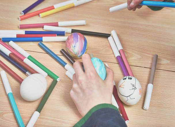 bambini che dipingono uova di Pasqua con l'aiuto della mamma e con i pennarelli a casa
 - Foto, immagini