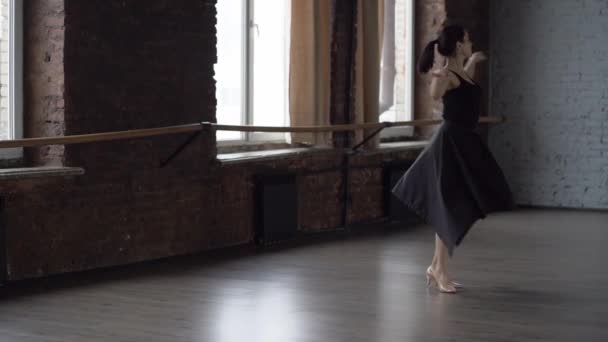 Grace lady in black dress makes turning in dance studio. - Footage, Video