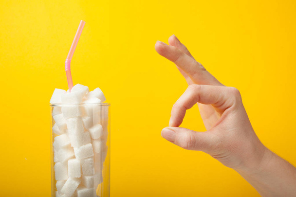 Un letrero con una mano y un vaso con azúcar, como concepto de una bodega
 - Foto, Imagen