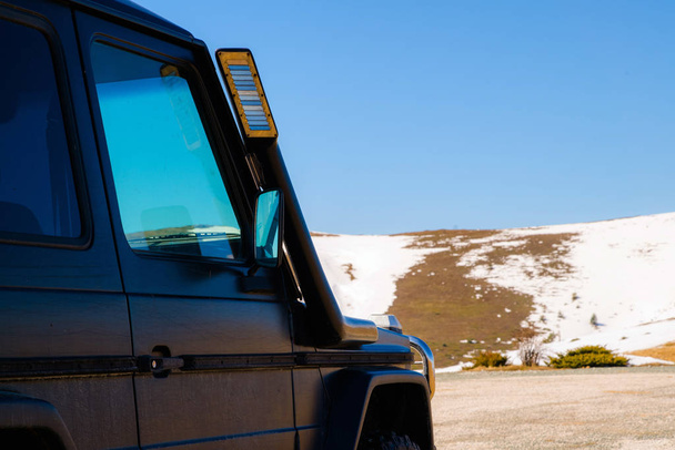 Off road 4x4 coche en las montañas nevadas en un día soleado. Viaje todoterreno, vehículo todo terreno en la naturaleza
 - Foto, Imagen