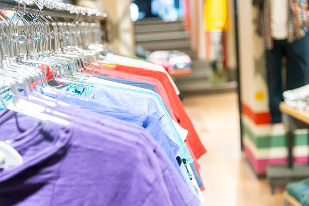 Kleurrijke t-shirts uitgelijnd in een jurk-winkel - Foto, afbeelding