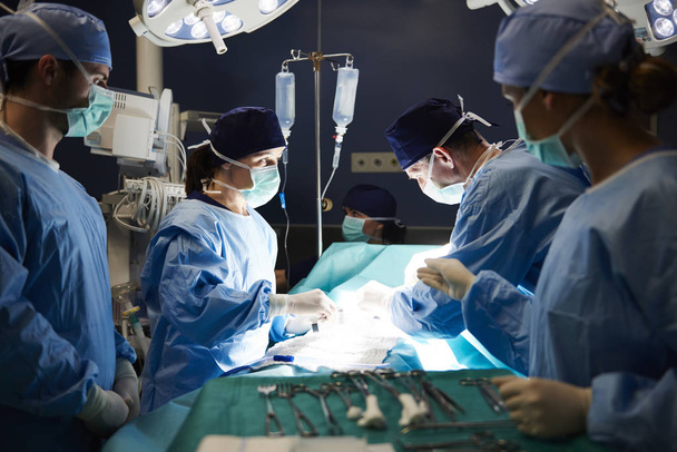 Gruppo di chirurghi impegnati sul tavolo operatorio
  - Foto, immagini