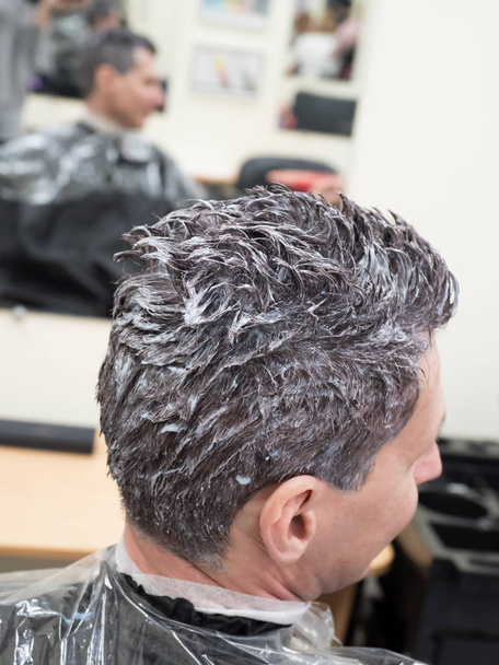 Tonificando el pelo gris en la cabeza del hombre en el salón de belleza
 - Foto, imagen