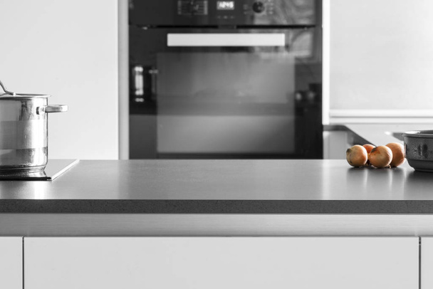 Mesa de cozinha com cebolas e uma panela
 - Foto, Imagem