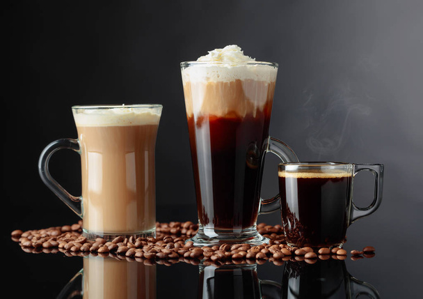 Diverse koffie drinken op een zwarte achtergrond. - Foto, afbeelding