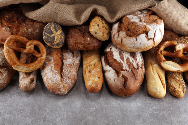 Assortment of baked bread and bread rolls on stone table backgro - Foto, immagini