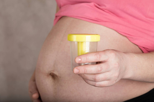 Jeune femme enceinte conserve récipient d'urine vide près d'elle être
 - Photo, image