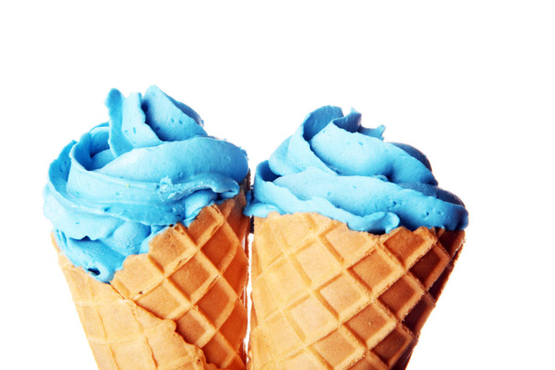 Wanilia mrożone jogurt lub kolorowe miękkie lody w wafel stożek. - Zdjęcie, obraz