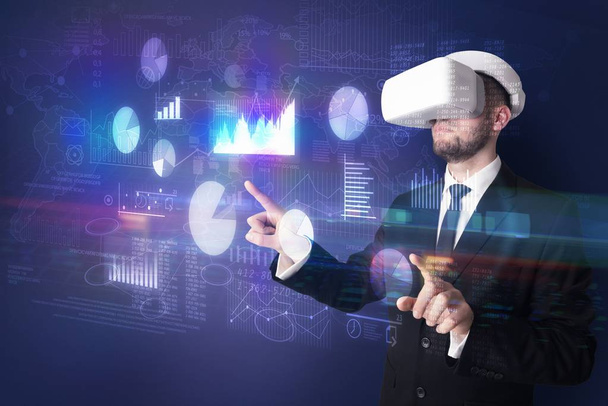 Man wearing VR goggles with charts and reports - Photo, Image