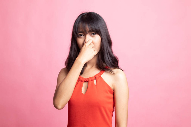 Młoda kobieta Azji, trzymając jej nosa ze względu na nieprzyjemny zapach. - Zdjęcie, obraz