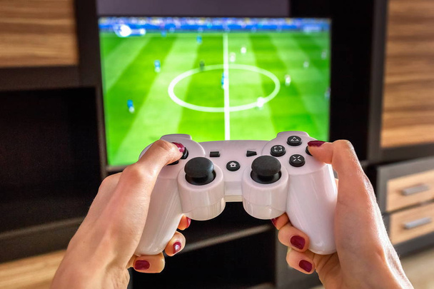 Білий ігровий джойстик, геймпад, стандартний контролер спрямований на телевізор, футбольний матч фіфа ps4, xbox
 - Фото, зображення