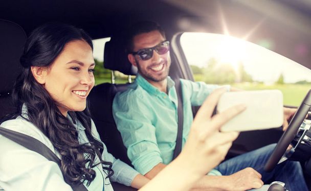 happy couple in car taking selfie with smartphone - Foto, Bild