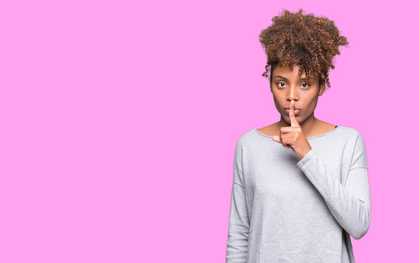 Красива молода жінка афро-американських над ізольованих фон просять, щоб бути спокійним пальцем на губах. Мовчання і секретний концепції. - Фото, зображення