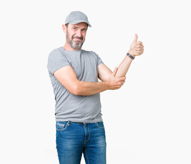 Гарний старший чоловік середнього віку в спортивній кепці над ізольованим тлом Дивлячись гордий, усміхнений робить великі пальці вгору жестом в сторону
 - Фото, зображення