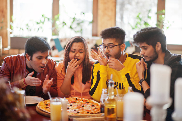 Group of asian friends eating pizza during party at pizzeria. Ha - Фото, зображення