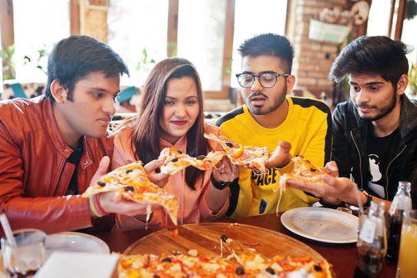 Group of asian friends eating pizza during party at pizzeria. Ha - Photo, Image
