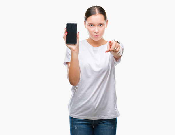 Νεαρή όμορφη γυναίκα Καυκάσιος εμφάνιση οθόνη smartphone πέρα από το απομονωμένο υπόβαθρο, δείχνοντας με το δάχτυλο στη φωτογραφική μηχανή και σε εσάς, το χέρι συνδεθείτε, θετική και σίγουρη κίνηση από το μέτωπο - Φωτογραφία, εικόνα