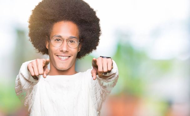 Jeune homme afro-américain aux cheveux afro portant des lunettes pointant vers vous et la caméra avec les doigts, souriant positif et joyeux
 - Photo, image