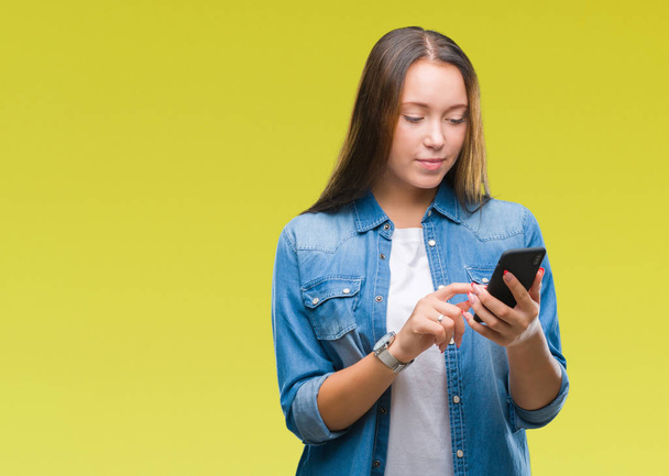 Young beautiful caucasian woman texting sending message using smartphone over isolated background with a confident expression on smart face thinking serious - Fotó, kép