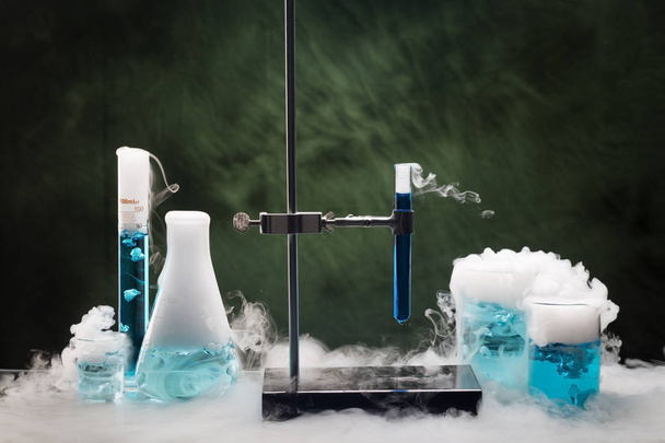 Glass tubes, beakers and flasks in the laboratory with fuming dry ice vapors. Sublimation of dry ice - Fotó, kép
