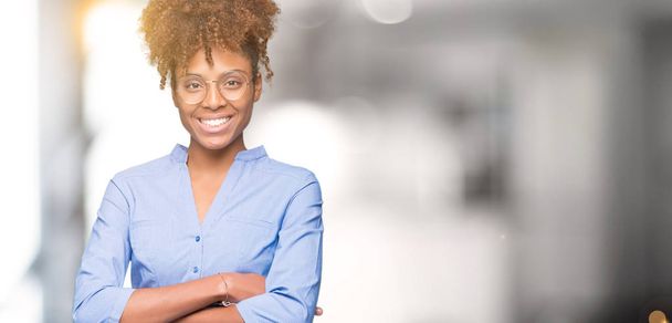 Belle jeune femme d'affaires afro-américaine sur fond isolé heureux visage souriant avec les bras croisés regardant la caméra. Personne positive
. - Photo, image