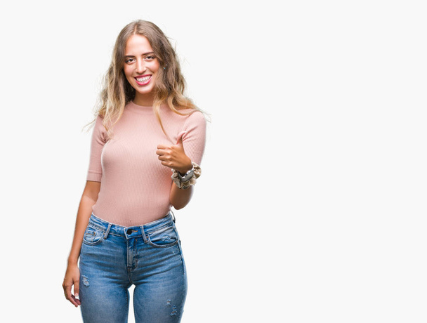 Beautiful young blonde woman over isolated background doing happy thumbs up gesture with hand. Approving expression looking at the camera with showing success. - Fotó, kép