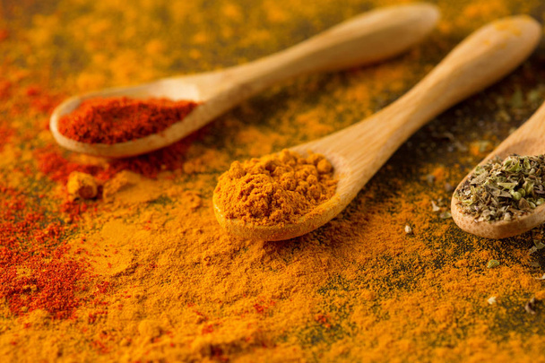 Spices and herbs on a dark background. Paprika, curcuma, chili pepper, parsley, basil, oregano. Cooking and healthy eating concept, selective focus - Fotografie, Obrázek