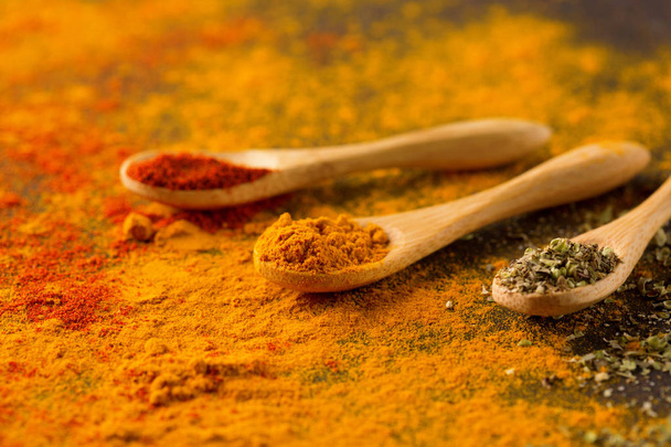 Spices and herbs on a dark background. Paprika, curcuma, chili pepper, parsley, basil, oregano. Cooking and healthy eating concept, selective focus - Foto, Imagen