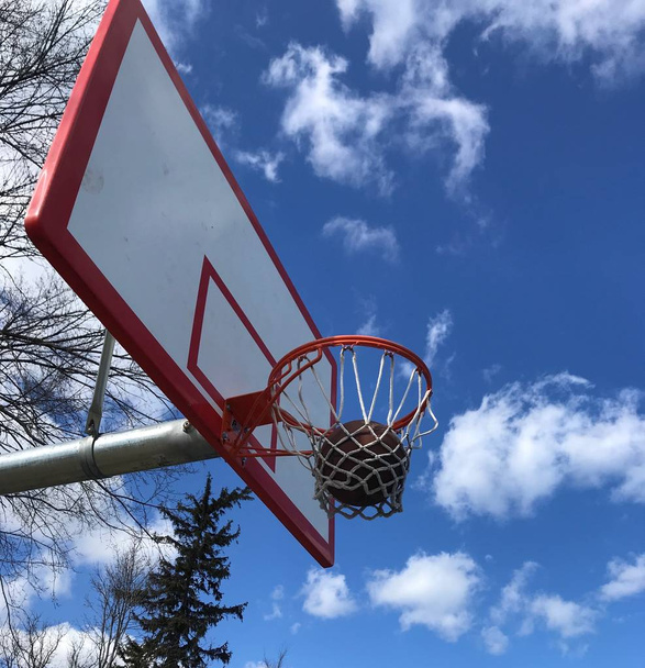 Basketbal swishes via het net tijdens het oefenen op de speelplaats. - Foto, afbeelding