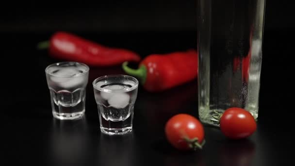 Cherry-tomaat broodje tot twee kopjes van wodka. Zwarte achtergrond - Video