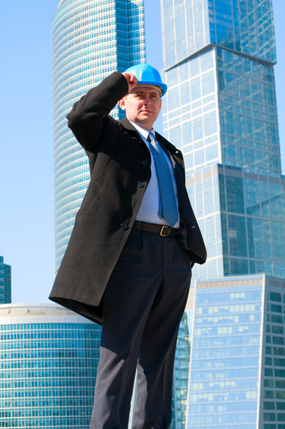Engineer with blue hard hat near skyscrapers - Valokuva, kuva