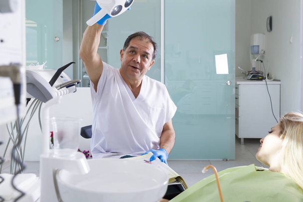 dentista masculino y paciente femenino en clínica dental
 - Foto, Imagen