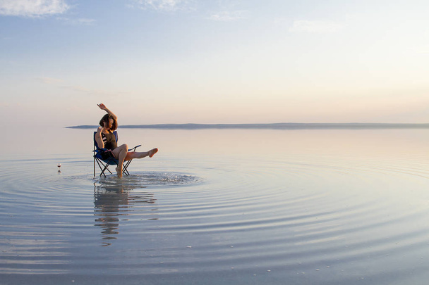 femme se reposant sur une chaise au bord de la mer pendant le coucher du soleil
 - Photo, image