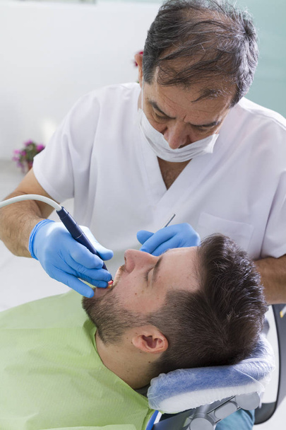 dentista y paciente masculino durante el procedimiento en la clínica dental
 - Foto, imagen