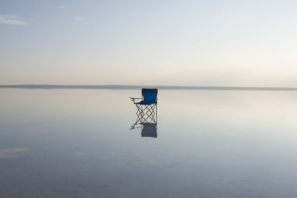 κλείνω πάνω θέα του κενή καρέκλα στέκεται στη θάλασσα - Φωτογραφία, εικόνα