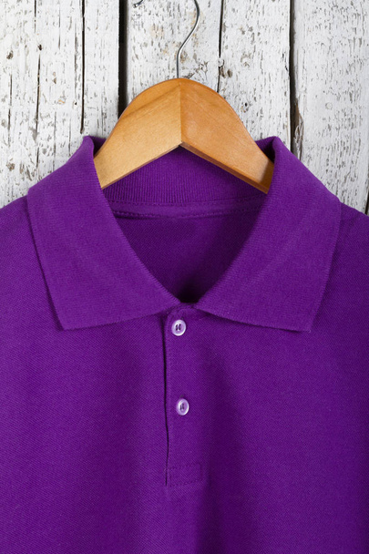 vista de cerca de la elegante camisa púrpura en percha sobre fondo de pared de madera
 - Foto, imagen