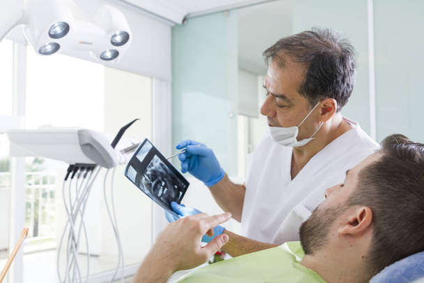 dentiste et patient masculin pendant l'intervention en clinique dentaire
 - Photo, image