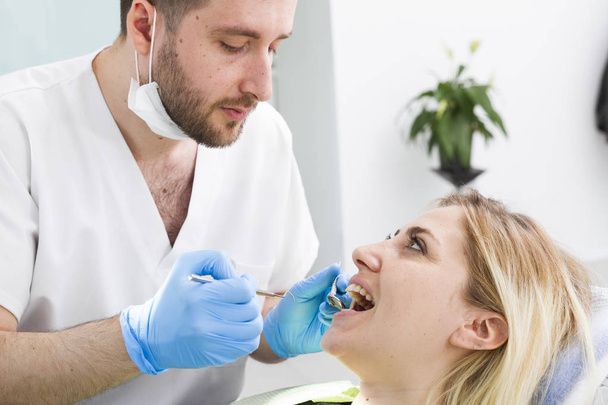 stomatologa i młodej pacjentki podczas zabiegu w klinice stomatologicznej - Zdjęcie, obraz