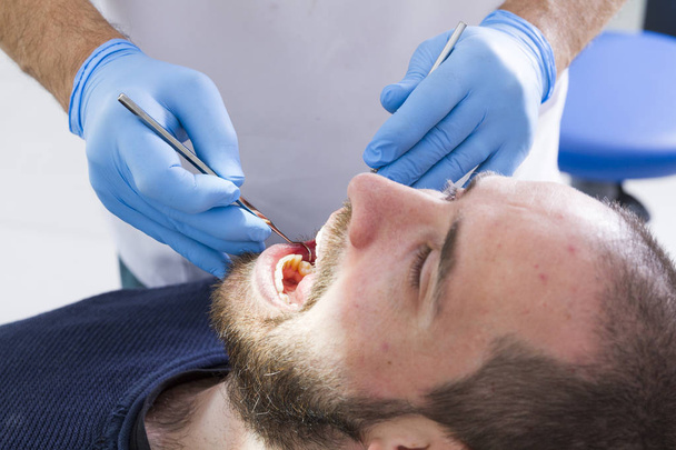 vista parcial del dentista y paciente masculino en clínica dental
 - Foto, Imagen
