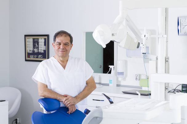 чоловічий стоматолог в уніформі в кабінеті стоматолога
 - Фото, зображення