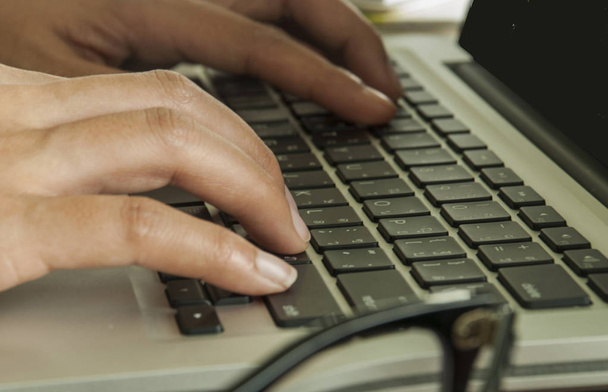 Imagen de cerca de una joven que está escribiendo en una computadora portátil
 - Foto, Imagen